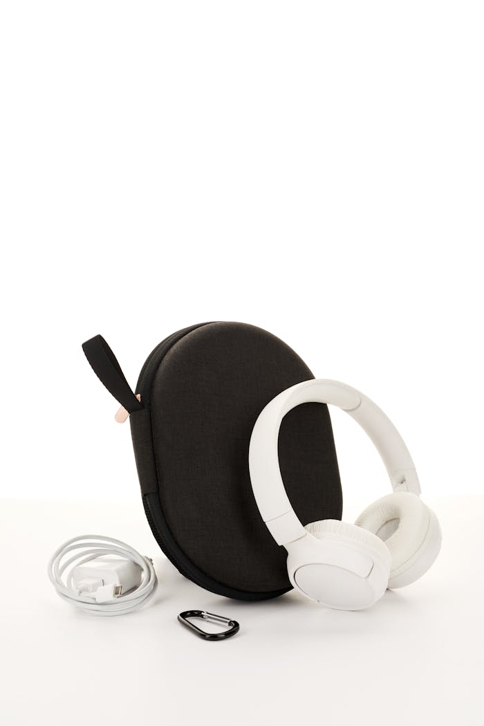 hero-img-02 Sleek white wireless headphones with a travel case, cable, and clip, perfect for music on the go.